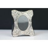 A silver easel back picture frame with embossed decoration