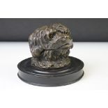 Brass inkwell modelled as a dog's head, with glass eyes, raised on a turned wooden base, 14cm
