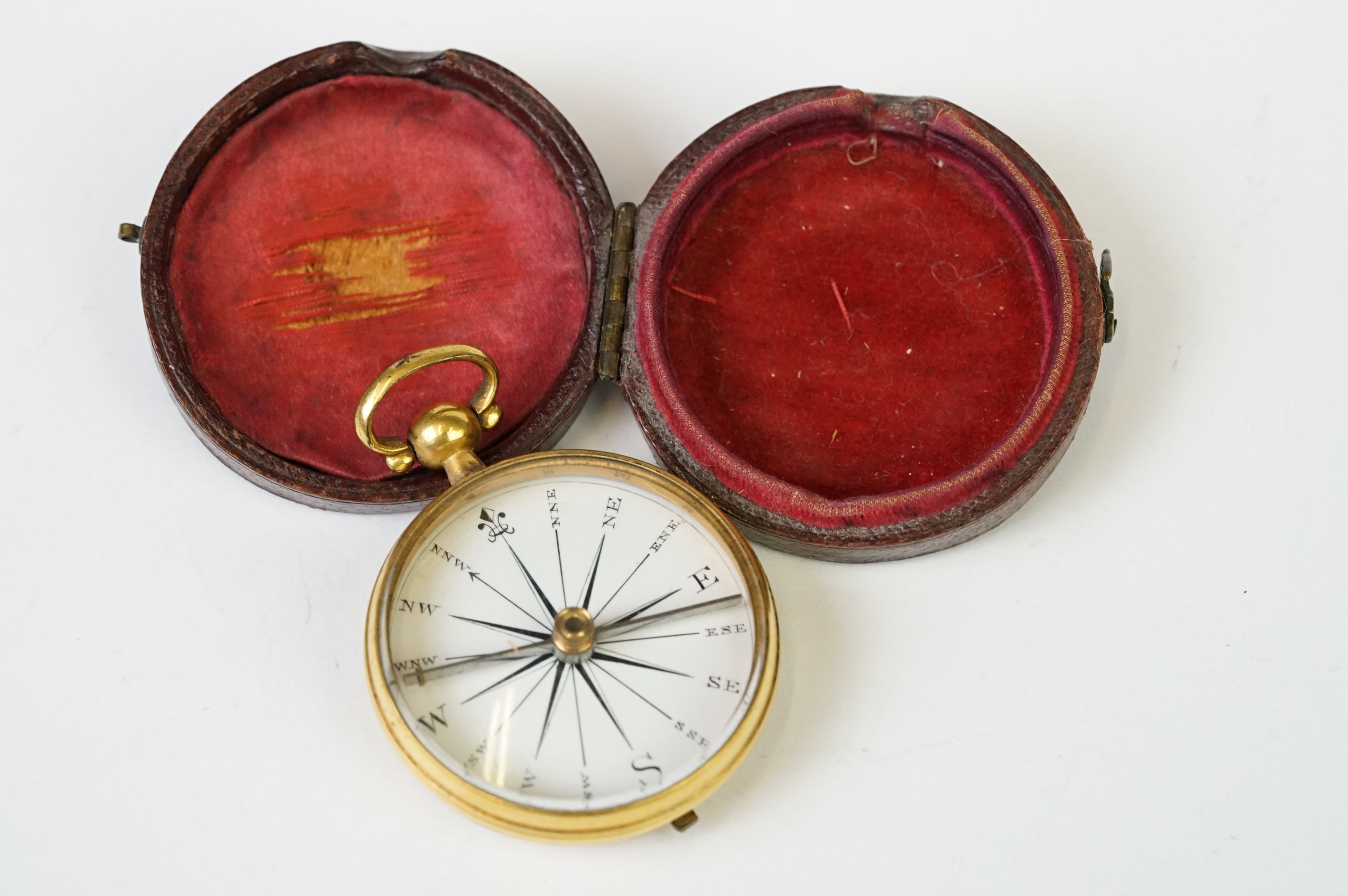 An antique brass cased pocket compass within original fitted protective case.