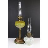A late 19th / early 20th century oil lamp with yellow glass reservoir together with another.