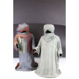 A pair of Middle Eastern leather figurative sculptures depicting Arabs in traditional costume.