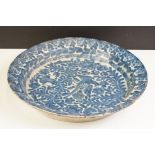 19th century blue & white pottery charger decorated with a bird amongst flora & fauna, 41cm diameter