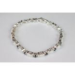 A silver opal and sapphire line bracelet.