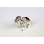 A silver dog pincushion.