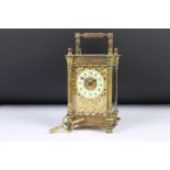 An antique French made carriage clock, brass cased with bevelled glass panels, decoratively detailed