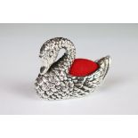 A silver swan shaped pincushion.