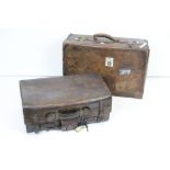Two vintage brown leather suitcases.