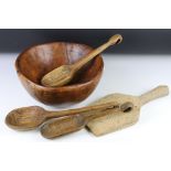A hand carved wooden bowl together with three carved wooden rustic spoons.