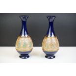 Pair of early 20th century Royal Doulton stoneware vases, with hand decorated foliate design, on
