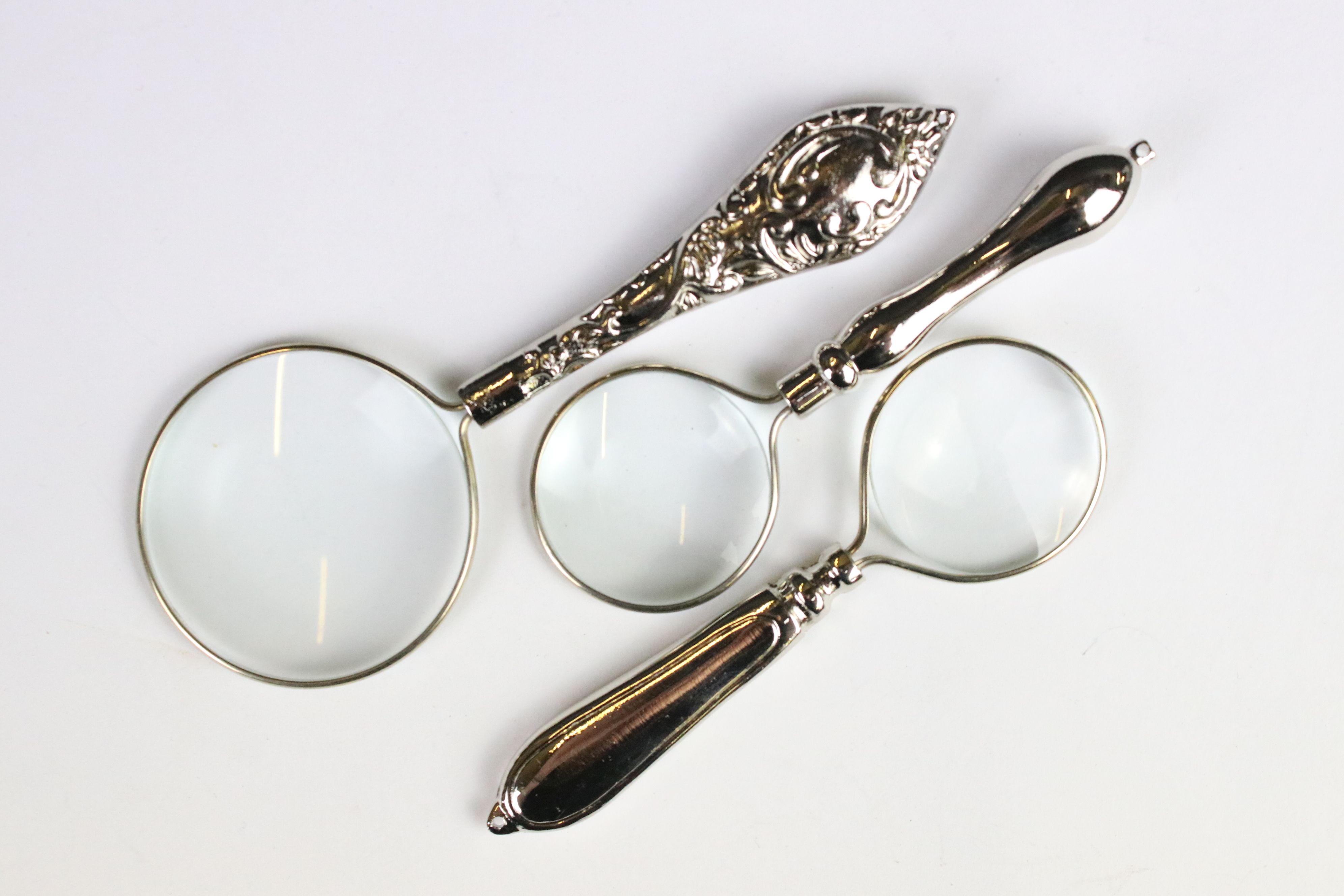 A set of three silver plated magnifying glasses.