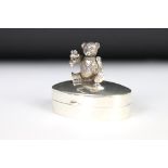 A silver oval pill box with articulated bear to the lid.