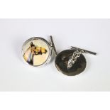 A pair of silver and enamel cufflinks depicting horses.