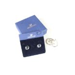 A pair of cased Swarovski earrings together with a pair of silver and diamond earrings.