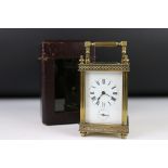 An antique French made carriage clock, brass cased with bevelled glass panels, white enamel dial
