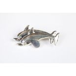 A silver dolphin brooch.