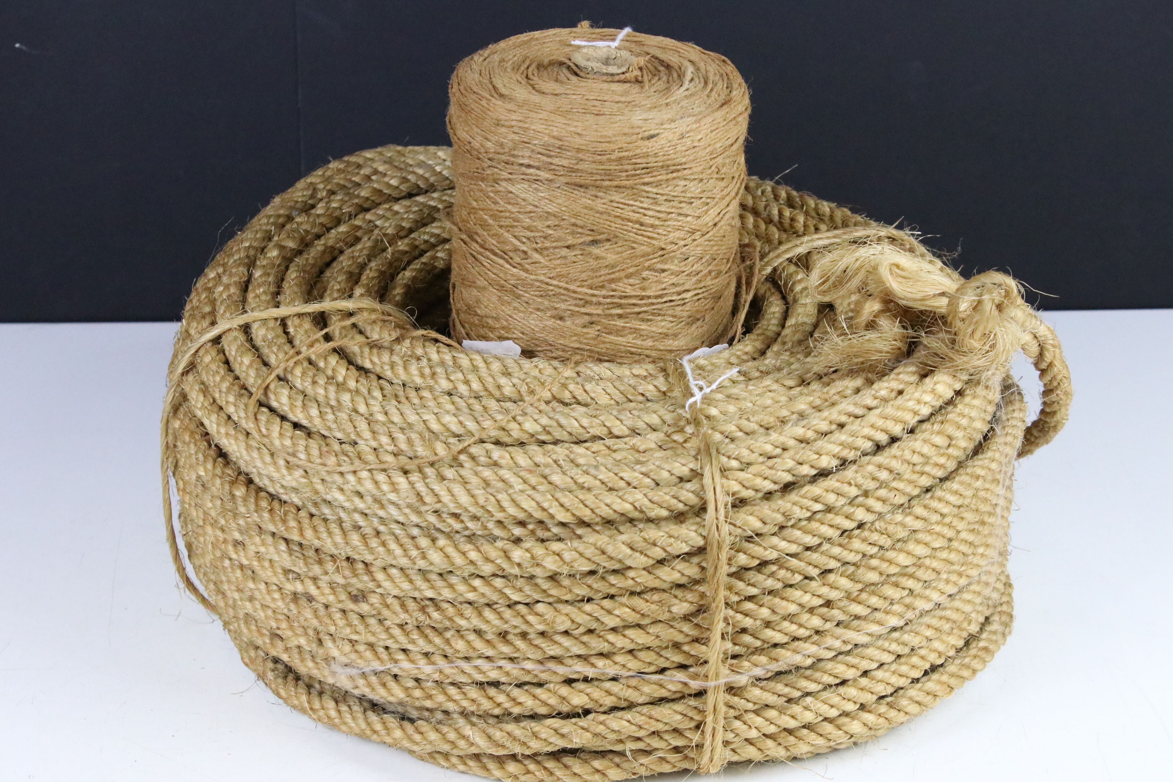 A vintage ball of brown string together with a roll of rope.
