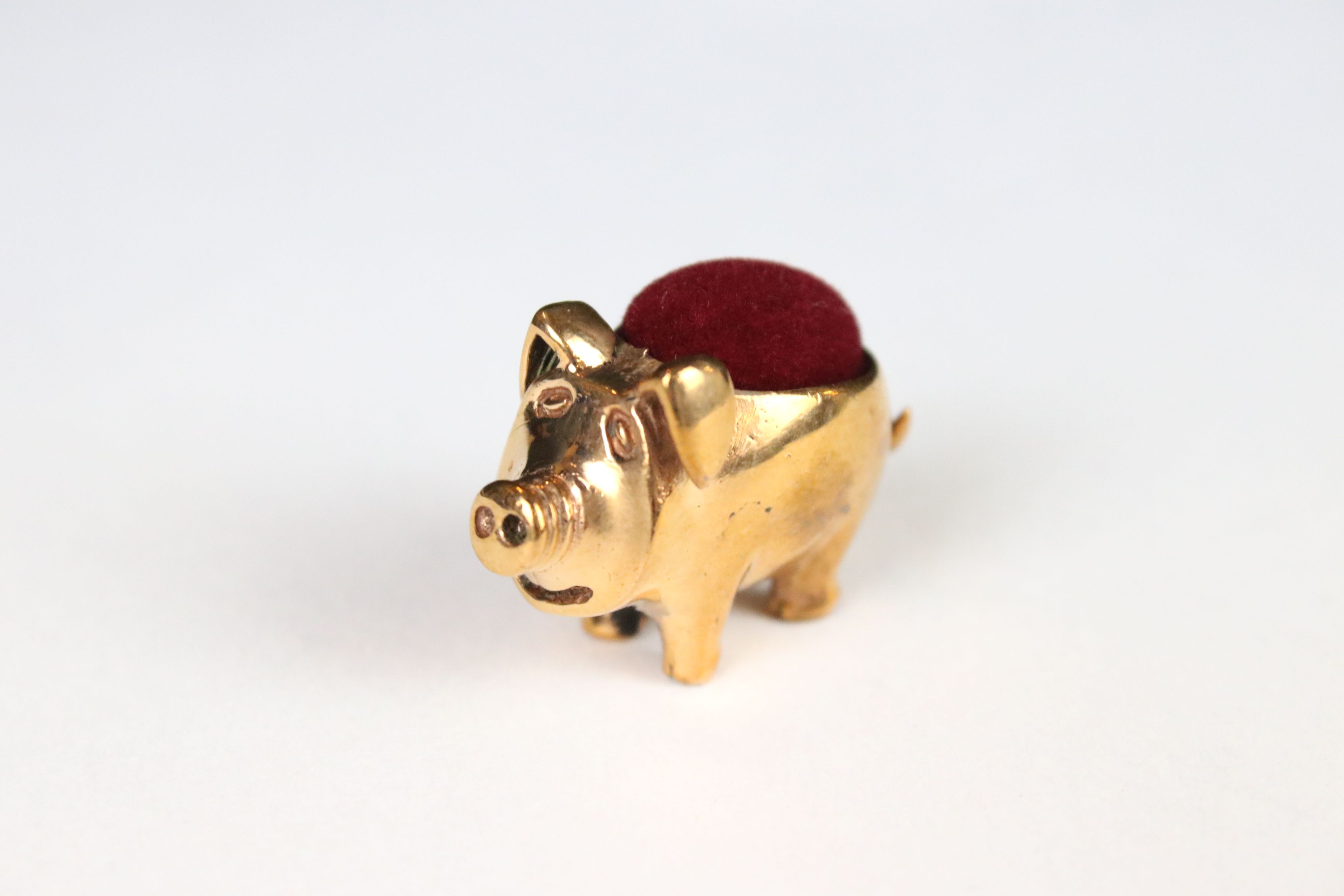 A copper pig pincushion.