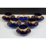 Part-set of Bohemian Czech gilt blue glass cups & saucers, relief decorated with floral motifs, to