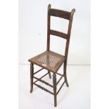 19th century Child's Correction Chair with cane seat and raised on turned bobbin supports, 37cm wide