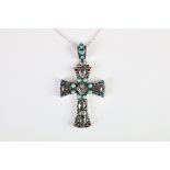 A silver pendant cross set with turquoise and ruby cabochons.