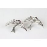 A pair of silver bird cufflinks with ruby eyes.