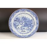 Chinese blue and white charger plate having a central hand painted scene featuring landscapes and