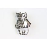 Silver brooch in the form of a pair of cats, one being set throughout with marcasites. Marked 925 to