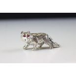 A silver figure of a fox with ruby eyes.
