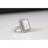 A silver CZ and large opal panelled ring.