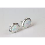 A pair of silver and pear shaped opal stud earrings.