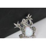 A silver and marcasite frog brooch with pear shaped opal panel.
