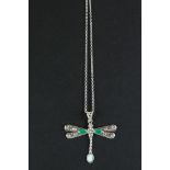 A silver dragon fly emerald set necklace.