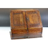 19th century oak stationery cabinet with fold-out doors, lower drawer with brass drop handle, and