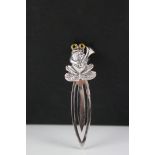 A silver bookmark with a frog finial.