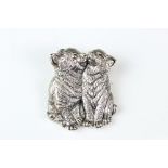 Two silver cats washing in the form of a brooch.