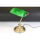 Brass bankers style lamp having a round stepped base with a green shade to the top. Measures 37cm
