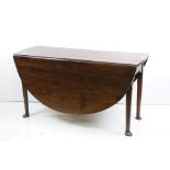 George III Oak Oval Drop Flap Supper Table, raised on four turned legs with pad feet, 154cm long x