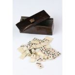 An antique miniature carved bone domino set within wooden box together with other bone miniatures.