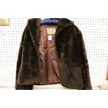 A collection of three vintage brown fur coats.