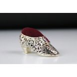 A silver plated shoe style pincushion with ruby cabochons.