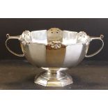 Edwardian silver twin-handled punch bowl of plain polished faceted form, scrolling to upper rim,
