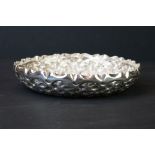 Late Victorian silver dish with chased repousse repeating floral border, crimped upper rim, plain