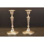 Pair of Edwardian silver hallmarked candlesticks having oval bases with a faceted column and base.