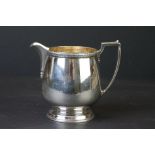 Silver milk jug, moulded circular foot, plain polished body, cast border, makers Adie Brothers