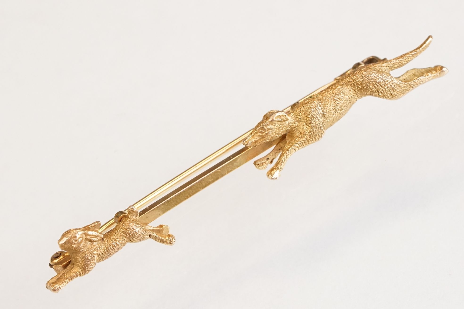 Early 20th century 9ct yellow gold bar brooch modelled as a hound dog chasing a rabbit, early 20th