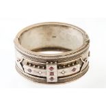 Victorian paste and seed pearl parcel gilt silver hinged bangle, the raised central section set with