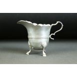 Early 20th Century Edwardian silver hallmarked cream jug. The jug having a scalloped rim raised on