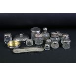 Collection of 12 silver lidded dressing table jars and scent bottle, featuring a silver lidded cut
