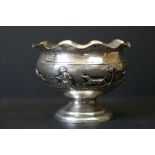 White metal pedestal bowl with repousse decoration depicting an African hunting scene, shaped rim,