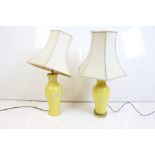 Pair of Chinese-style yellow glazed table lamps of baluster form, with shades. Measure approx 70cm